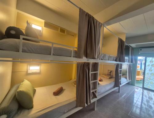 a room with three bunk beds in a room at DK1Hostel in Chaweng