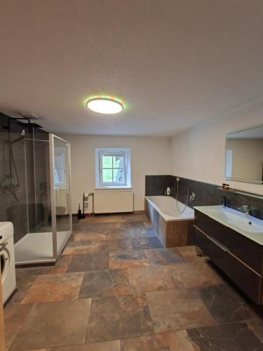 a large bathroom with a tub and a sink at Gästehaus Hammerle Holzgau in Holzgau