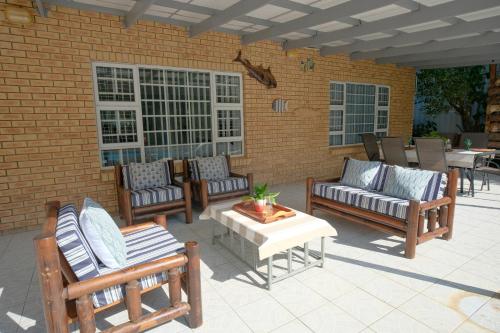 a patio with a bunch of chairs and a table at Kuda Breeze in St Lucia
