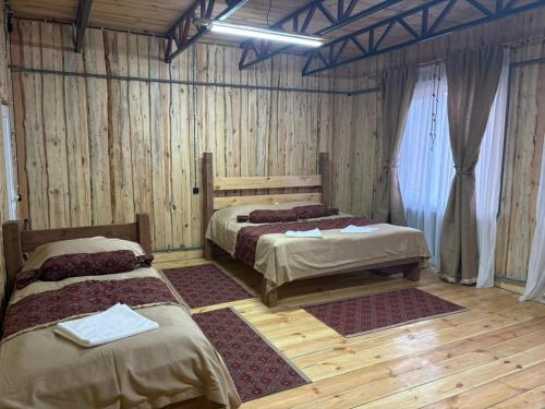 two beds in a room with wooden floors at Kolsay Aisha in Saty
