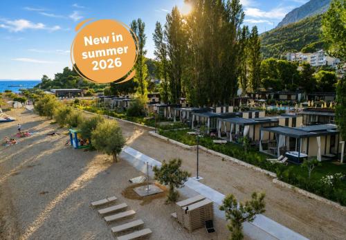 a view of a new in summer sign and a beach at Camping Almissa in Omiš