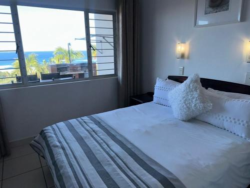 a bedroom with a bed with a view of the ocean at #9 Illovo Views in Kingsborough