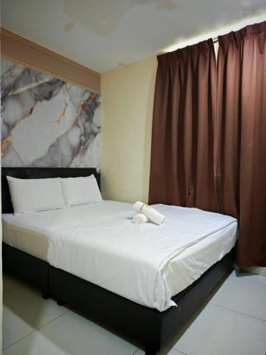 a bedroom with a large bed with a white bedspread at 28 Gred Hotel in Bukit Mertajam