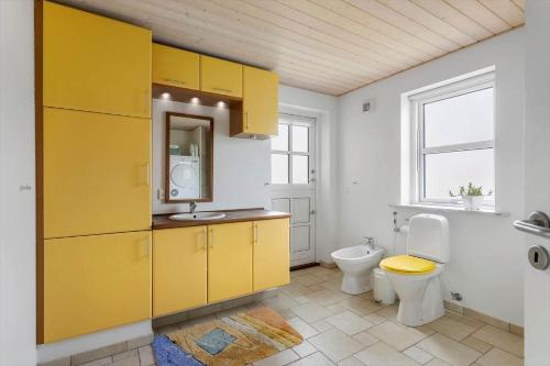 a yellow bathroom with a toilet and a sink at FY166-Middelfart-Skrillinge-Strand-100 in Middelfart