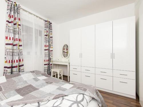 a white bedroom with a bed and a desk at Apart Peter in Seefeld in Tirol