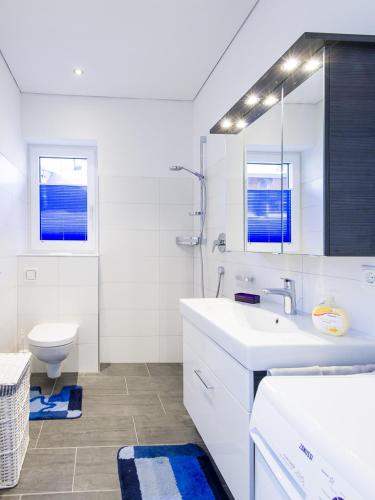 a white bathroom with a sink and a toilet at Apart Peter in Seefeld in Tirol
