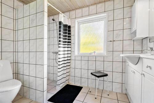 a bathroom with a shower and a toilet and a window at C11306-Tarm-Hjortevej-10 in Tarm