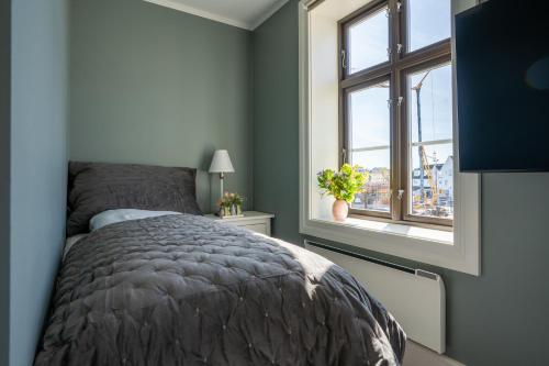 ein Schlafzimmer mit einem Bett und einem Fenster in der Unterkunft Bakerigården in Lillesand