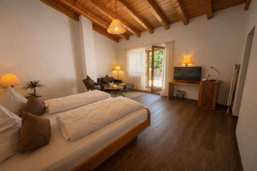 ein Schlafzimmer mit einem großen Bett und ein Wohnzimmer in der Unterkunft Hotel Suggenbad in Waldkirch