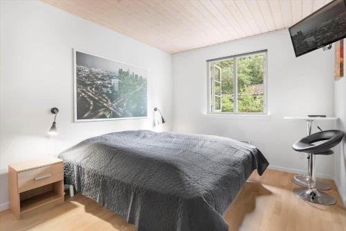 a bedroom with a bed and a chair and a window at 945-Frederiksvaerk-Soltoften-3 in Frederiksværk