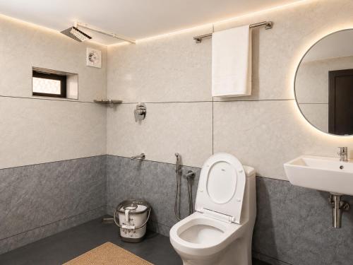 a bathroom with a toilet and a sink and a mirror at Chooravelil Villa, Adimali - Family Stay Near Munnar in Anniyartholu