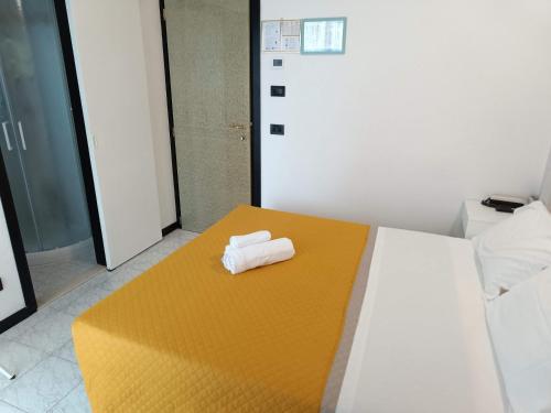 a room with a bed with two towels on it at Hotel Criniera D'oro in Rimini