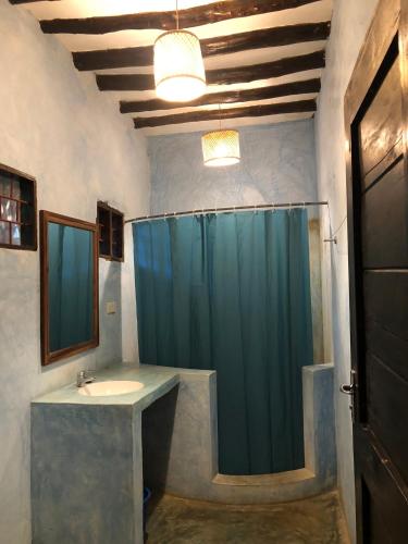a bathroom with a shower and a sink at Casa Umoja in Nungwi