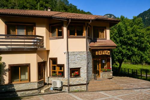 ein großes Haus mit Veranda und Balkon in der Unterkunft Family Hotel Fedora in Ribarica