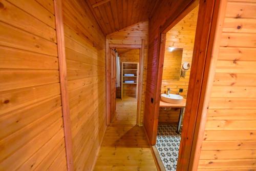 a hallway leading to a bathroom in a log cabin at Eden Bungalows and Beach in Köyceğiz