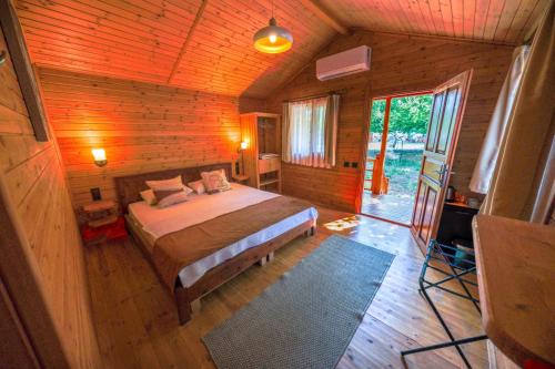 a bedroom with a bed in a wooden cabin at Eden Bungalows and Beach in Köyceğiz