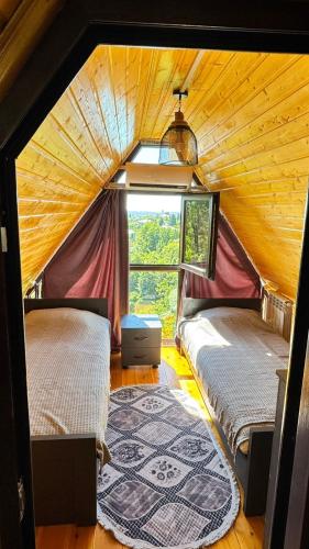 two beds in a room with a window at Alamabari Inn in Kobuleti