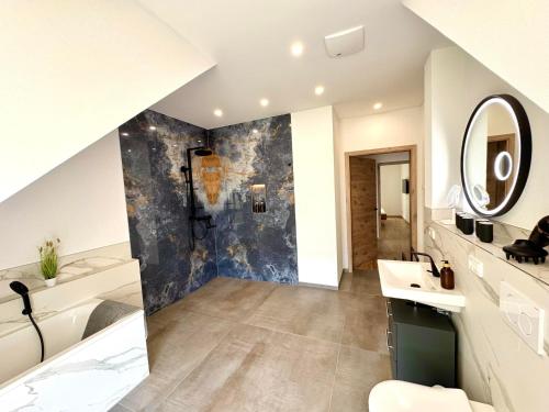 a bathroom with a sink and a mirror at Ferienwohnanlage Einzigartig in Saarburg