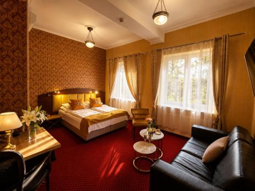 a hotel room with a bed and a couch at Hotel Galicja SPA Wieliczka in Wieliczka