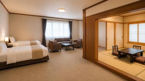 ein Hotelzimmer mit Bett und Spiegel in der Unterkunft Livemax Resort Isawa Onsen in Fuefuki