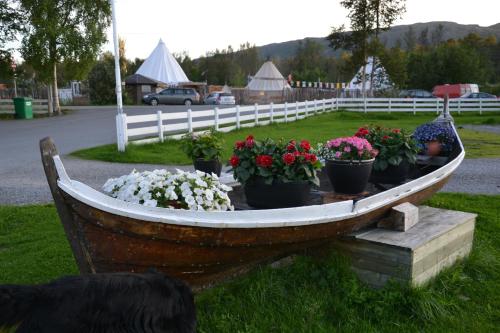 a wooden boat with flowers in it on the grass at Alta River Camping in Alta
