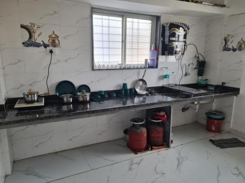 a kitchen with a sink and a counter top at Umahomestay in Nashik