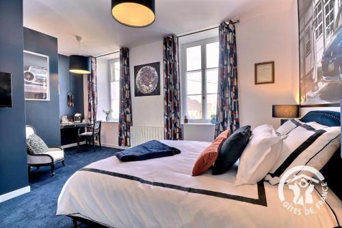 a bedroom with a large bed and a desk at Le rok in Billé