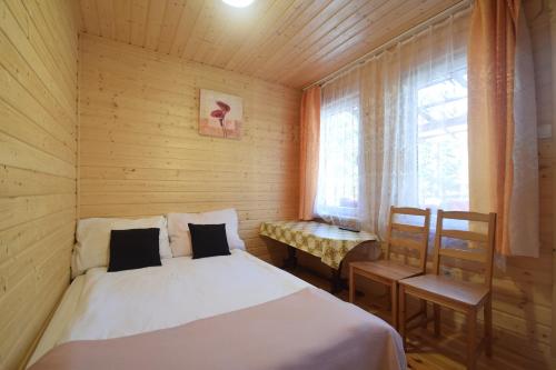 a bedroom with a bed and a table and a window at Domek Letniskowy Paweł in Pogorzelica