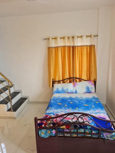 a bedroom with a bed with an orange curtain at Umahomestay in Nashik