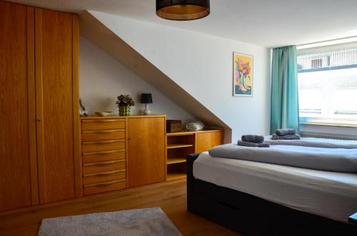 a bedroom with two beds and a dresser at Ferienwohnung NORA - direkt am Bodensee in Friedrichshafen