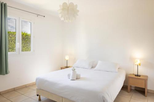 a bedroom with a large white bed with two lamps at Casa Mia in Porto-Vecchio