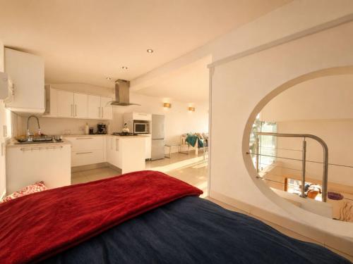 a bedroom with a red blanket on top of a bed at '24 Gordonia', Spacious Condo - Sleeps 7, Sea Front, Easy Beach access in Gordonʼs Bay