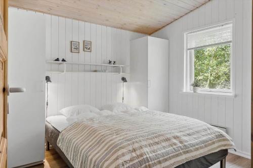 a white bedroom with a bed and a window at LF10316-Hurup-Thy-Vagtelvej-16 in Sønder Ydby