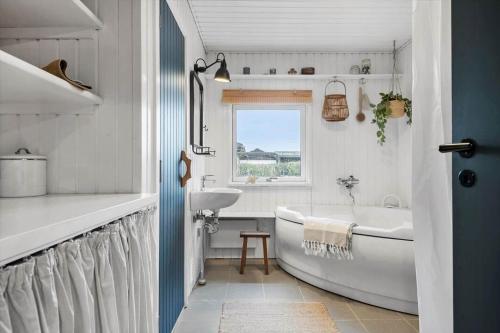a white bathroom with a tub and a sink at 30116-Odder-P-Baatrupsvej-47 in Odder