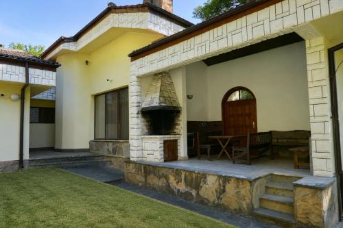 a house with a patio and an outdoor oven at Guest House Fedor in Ribarica