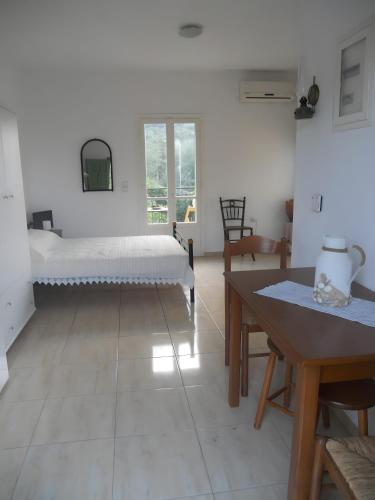 a white room with a bed and a table at Afales Villa and Studios in Exoyí