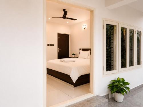 a bedroom with a bed and a window at Chooravelil Villa, Adimali - Family Stay Near Munnar in Anniyartholu