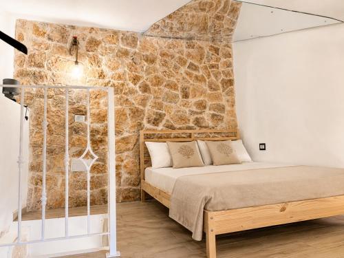 a bed in a room with a stone wall at Rallenta Casamassima in Casamassima
