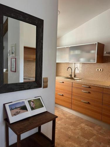 a bathroom with a mirror and a table with a sink at Casa Enric , con zona infantil, piscina y parking privado in Deltebre