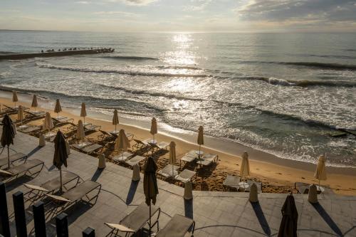 a group of chairs and umbrellas on a beach at HVD Nympha Hotel - All Inclusive, Private Beach & Free Parking - Adults Only in Golden Sands