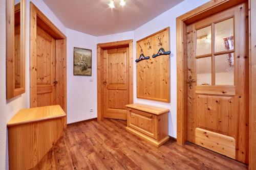 a room with wooden walls and wooden floors and doors at Gästehaus Anneliese in Wallgau