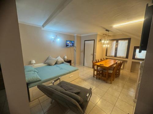 a bedroom with a bed and a dining room with a table at La Casa di Maya a due passi da Sestriere in Grange Sises