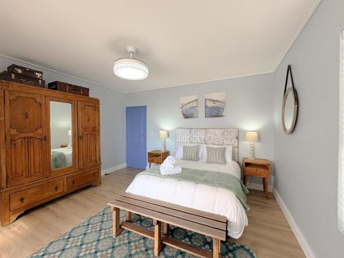 a bedroom with a large bed and a wooden cabinet at Swordfish Retreat in St. Helena Bay