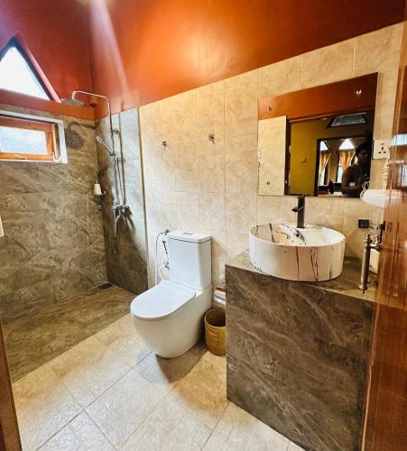 a bathroom with a toilet and a sink and a shower at My Village in Tissamaharama