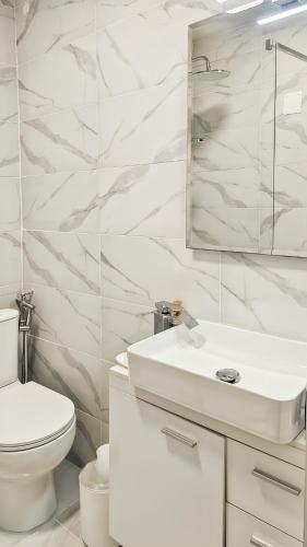 a white bathroom with a toilet and a sink at Limone Piemonte Kids Friendly in Limone Piemonte