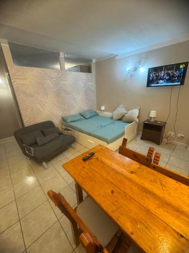 a room with a bed and a couch and a table at La Casa di Maya a due passi da Sestriere in Grange Sises