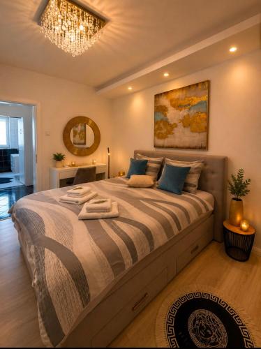 a bedroom with a large bed with a chandelier at Apartment "Mimoza 1" self check-in, self check-out in Otočac