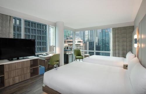 a hotel room with a bed and a large window at Coast Coal Harbour Vancouver Hotel by APA in Vancouver
