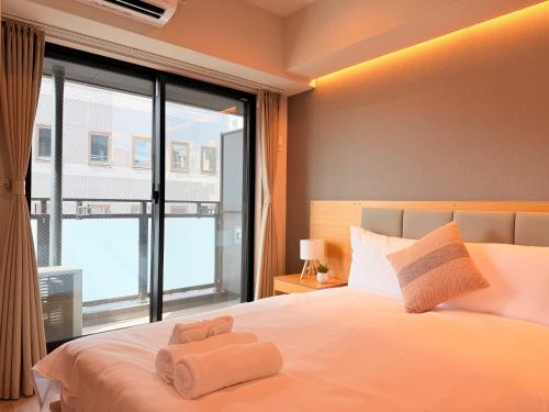 a bedroom with a bed with two towels on it at LuxuryHOTEL難波南 in Osaka