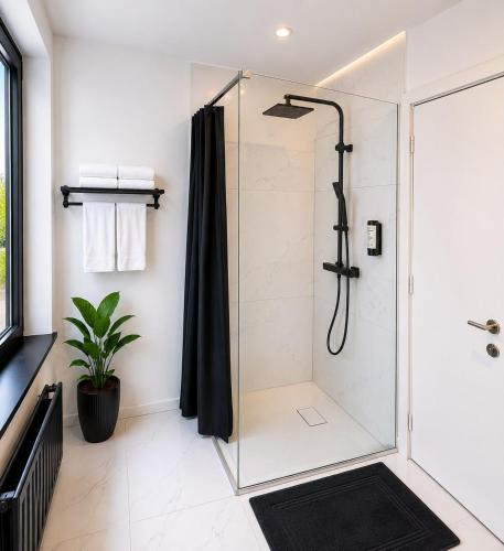 a bathroom with a shower with a black shower curtain at Hotel Albergo in Brussels